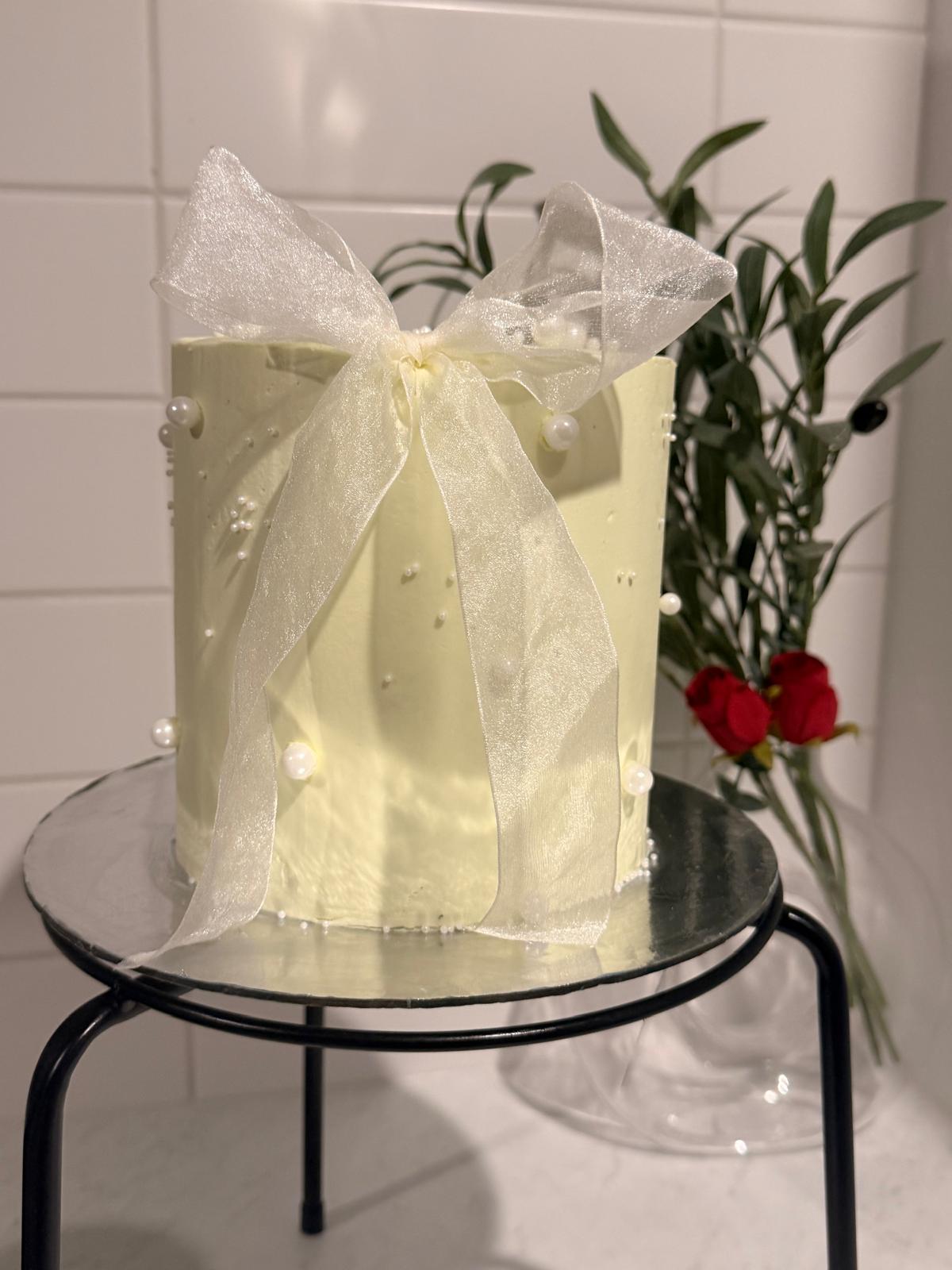 Tall white cake with lace bow detailing